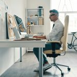 Elderly man in front of a laptop